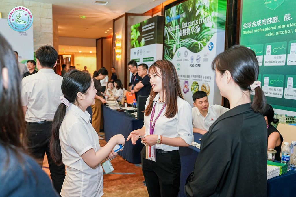 Cixiang Pharmtech team communicating with visitors at the 2026 China Flavor and Fragrance Industry Conference, introducing cinnamon series products such as cinnamic acid and cinnamaldehyde.